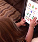 Toddler using ipad to view baby sign language poster