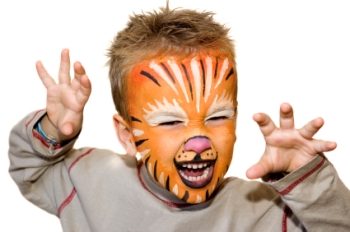 toddler art activities picture, shows cute little boy wearing face painting, orange white and red, with his hands outstretched and a mock scary face