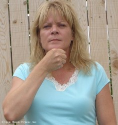 image shows a blond woman making the asl sign for orange using an s handshape squeezing from the chin area image shows a blond woman making the asl sign for orange using an s handshape squeezing from the chin area